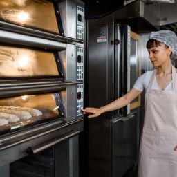 Woman pushing buttons on oven equipment