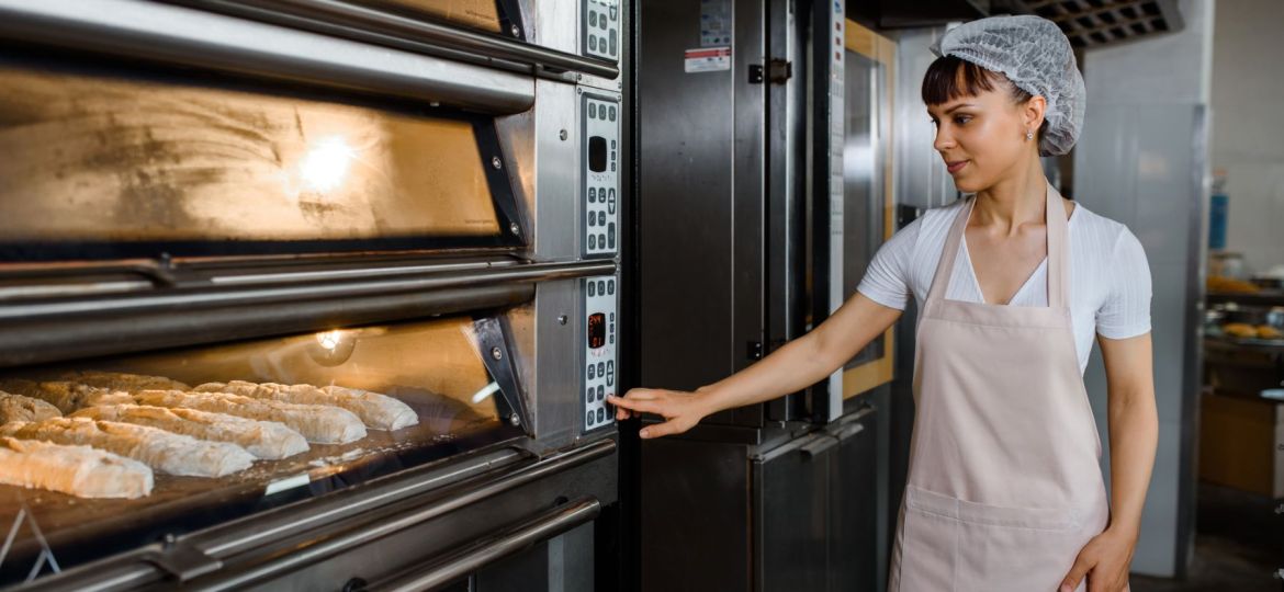Woman pushing buttons on oven equipment